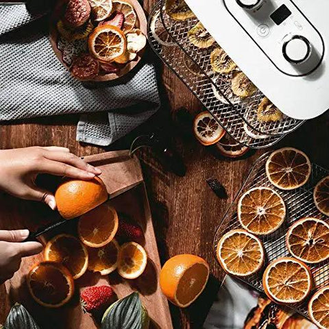 Digital Electric Food Dehydrator With Four Stackable Stainless Steel Trays and Precision Temperature Controls Featuring A Rock Solid Forty Eight Hour Timer For Sick Fast Jerky Fruit Veggie And Herb Preservation with sliced oranges on wooden board.