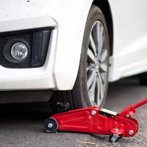 Front Wheel Replacement For Two And A Half Inch Iron Wheel For Two Ton Hydraulic Floor Jacks Heavy Duty Pro Grade Universal Roller Accessory With Professional Bearing For Horizontal Jack And RV Stabilization, shown installed on a red hydraulic jack under a car.