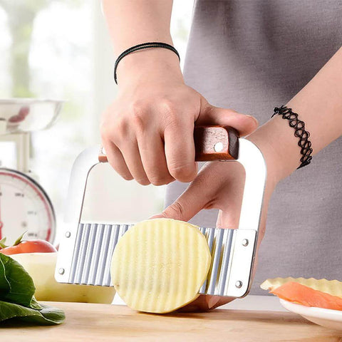 Front view of BANCOO 2-piece crinkle cutter with wooden handle and stainless steel wavy blade cutting a potato