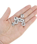Hand holding stainless steel snap fasteners from the 200-Piece Stainless Steel Snap Fastener Kit, 15mm Snap Caps, for DIY repairs.