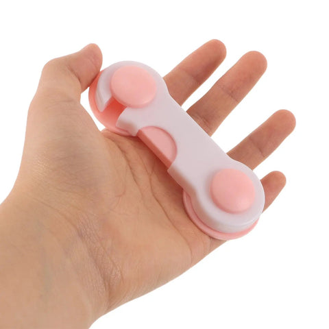 Person holding an Eight Pack No Drill Cabinet Lock with Ultra Sticky Adhesive, showcasing its compact size and pink ABS material