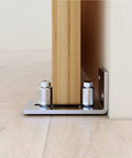 Scratch Resistant Stainless Steel Flush Mount Stay Roller Floor Guide For Doors Up To Two And One Eighth Inches Thick With Flat Bottom Design Keeps Floors Free Of Grooves And Provides Easy Wall Mount Installation With Included Screws And Hardware installed on wooden door.
