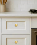 Luxury Solid Real Unlacquered Brass Cabinet Knobs Handmade Heavyweight Builds on white kitchen drawers, offering a sleek patina.