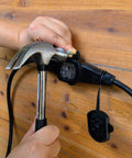 Person securing Heavy Duty 30Ft 14/3 Extension Cord With Six Outlets Spaced Every 5 Feet For Indoor Outdoor Use to a wooden surface