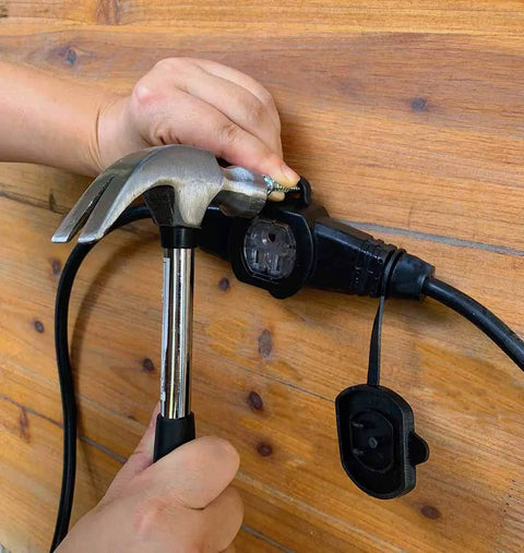 Person securing Heavy Duty 30Ft 14/3 Extension Cord With Six Outlets Spaced Every 5 Feet For Indoor Outdoor Use to a wooden surface