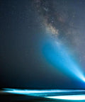 Silhouette holding Tough As Nails Four Cell D Flashlight with Xenon Bulb 98 Lumens shining under starry sky.