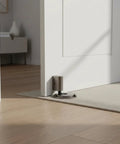 Solid Zinc Alloy Door Stopper With Suction Holder For Floor And Walls Holds Tight Against Wind To Keep Bedroom Office Quiet And Safe From Slams positioned at door threshold.