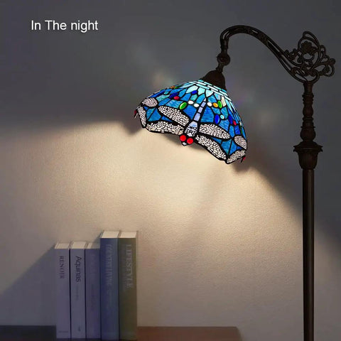 Tiffany Style Stained Glass Floor Lamp 62 Inch Tall With Blue Dragonfly Shade, soft ambient light, arched arm in living room at night.