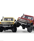 Two RC vehicles with metal chassis frames, one yellow and one red, demonstrating upgrades for 1/12 scale MN82 LC79 crawlers.