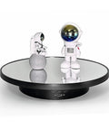 Ultimate 3 In 1 Motorized Rotating Display Stand With 360 Degree Electric Turntable And Swappable Covers For Professional Product Photography, Jewelry Shoots, Cake Presentations, And Live Videos In Sleek Black showcasing astronaut figurines.