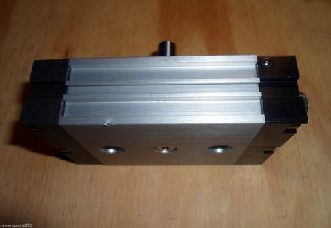 Front view of Smc Cdrqb 20 rotary air cylinder with silver aluminum body and black end caps.