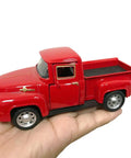Hand holding a Red Metal Truck Christmas Decor For Farmhouse Style Vintage Pickup Truck Tabletop Storage Die Cast Metal With Hand Painted Finish