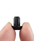 Close-up of a Grate Rubber Feet Replacement for Cooktop Burners, heat-resistant rubber foot pad, held between two fingers.