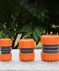 Three orange Garden Hose Repair Kit For 1/2 Inch Hoses, Quick Connect Connectors, Hose Extender shown against greenery background.