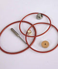 Pneumatic valve repair kit components: several red O-rings, brass discs, metal fittings.