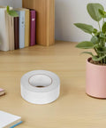 Slick Heavy Duty Double Sided Tape For Quick Fixes And Secure Mounting Reusable Transparent Adhesive Roll on wooden desk.