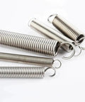 Close-up of 100 Piece Stainless Steel Extension And Compression Spring Kit With Hooks For Home Repairs, various sizes on white background