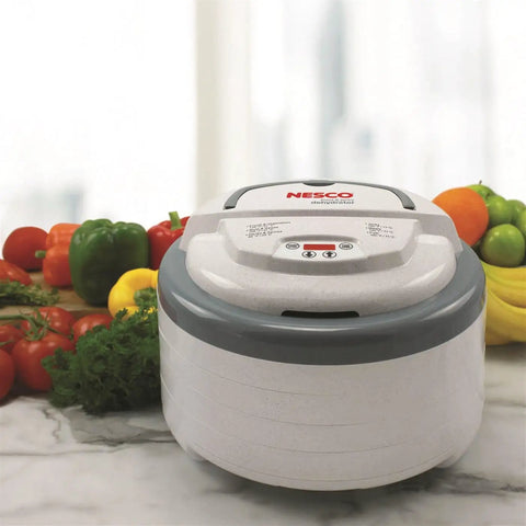 Digital Food Dehydrator With Smooth Adjustable Temperature And Even Heating For Whipping Up Homemade Beef Jerky Dried Fruit Fresh Herbs And Crispy Snacks On Four Stackable Trays In A Sleek Gray Design With Fresh Vegetables In Background.