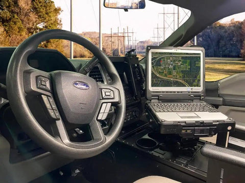 Heavy Duty Laptop Docking Station Featuring Advanced Port Replication Dead Simple Setup And Secure Quick Release Lock Built Like A Tank For Hard Core Field Crews installed in a vehicle.