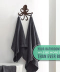 Rad Cast Iron Octopus Wall Hook Rustic Brown Antique Finish with towels hanging, adding nautical decor to a bathroom.