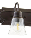 Close-up of a light on Transitional Five Light Vanity Fixture in Oiled Bronze with Clear and Seeded Glass Damp Rated Bathroom Lighting 36 Inch