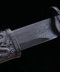 Close-up of a Beefy Damascus Tang Dao Sword with Black Gold Finish, showing the intricate alloy fittings and traditional folding pattern.