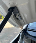Close-up of Beefed-Up Front Hood Lift Struts For Jetta MK7 2019-2025 showing hydraulic gas spring attachment.