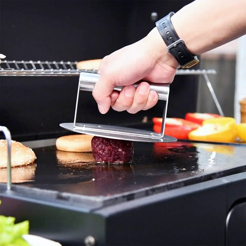 Hand using Stainless Steel Burger Press Round 6.2 Inch Smasher on grill for even restaurant-style patties