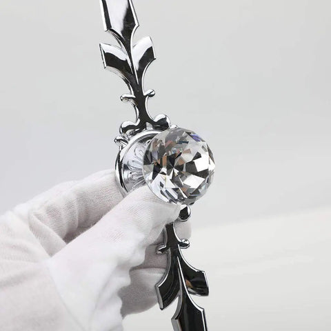 Close-up of a 12 Pack Diamond Clear Crystal Glass Cabinet Knob Set with Plate and Screws, silver detail held in a gloved hand.