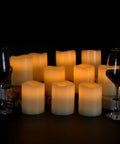 Flameless Battery Operated Pillar Candles Set Of 12 Real Wax Pillars With Dancing LED Flames 3 Inch By 4 Inch Ivory on table