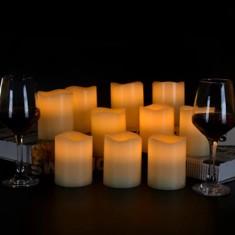 Flameless Battery Operated Pillar Candles Set Of 12 Real Wax Pillars With Dancing LED Flames 3 Inch By 4 Inch Ivory on table