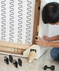 Man installing Heavy Duty Sectional Sofa Connectors Twenty Pack Metal Interlocking Alligator Pins under couch frame.
