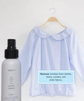 The Ultimate 3 In 1 Wrinkle Release Spray That Kicks Static Cling And Cuts Odor For Crisp Clothes Without Ironing In A Legit Plant Derived Quick Fix 3 Oz Travel Bottle With No Sweat Fabric Refresher Power next to a light blue blouse.