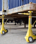 Two Tough As Nails 2 Pack Semi Trailer Stabilizing Jacks in yellow under a trailer, designed for heavy-duty load support.