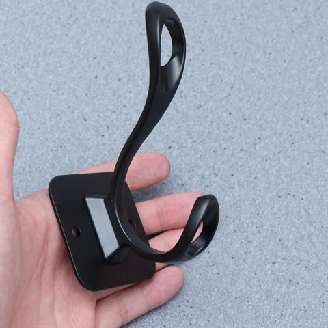 Vintage Matte Black Wall Hooks Set Of Five For Hanging Heavy Coats Umbrellas And Handbags Boasts Dope Industrial Vibes And Rock Solid Screw Mount Hardware held in hand showing hook design.
