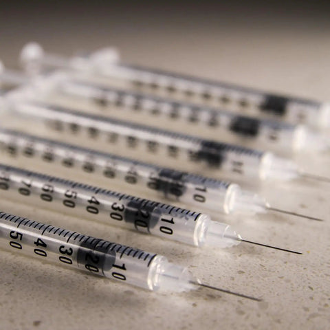 Close-up of 30 Gauge 1ml Syringes Set Pro Grade, 5 By 16 Inch, clear scale for ink glue paint lab use, box of 100, lined up.