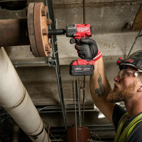 Hard Hitting Brushless Impact Wrench With Friction Ring Unleashes Knockout 1400 Foot Pounds Of Torque For Swift Socket Swaps And Beefy Fastening Tasks Compact 18 Volt Cordless Power Tool Built Like A Tank For Real World Applications in use on a metal flange.