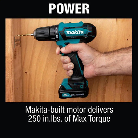 Hand holding 12V Max Cordless Drill Driver Kit With 3/8 In Chuck Two 2Ah Batteries Renewed Variable Speed against wooden board