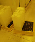 Yellow Nestable Spill Pallet For Oil Drums Leak Proof Drum Containment Tray shown with containers in garage storage setup.