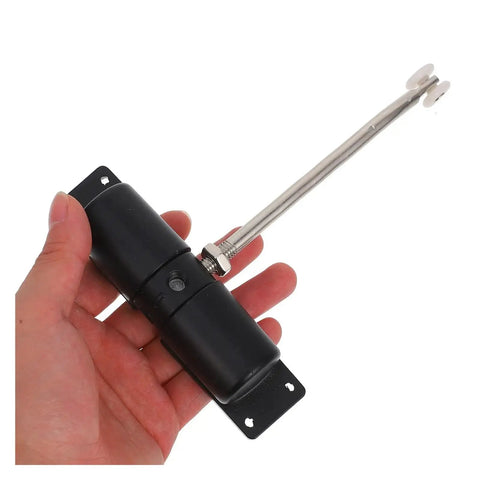 Hand holding automatic door closer with spring hinge for home doors, garden gates, stainless steel tough metal build.