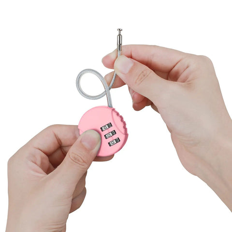 Hand holding pink lock from Two Pack 3 Digit Combination Padlock Outdoor Waterproof Lock For School Gym Lockers Luggage Toolbox Fence Gate Case And Storage Black And Pink Ready For Home Office Travel Camping And Everyday Use