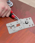 Metal connector bracket being installed on wooden surface with tools, part of Lock Your Sectional Sofa Down Tight With These Hella Sturdy Five Piece Metal Connectors Adjustable Brackets Bite Wooden Frames For A Rock Solid Fit That Stops Pieces From Shifting Around.