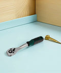 Heavy Duty 10mm Quick Release Ratchet Extension Featuring 72 Tooth Reversible Head For Mechanics Seeking Straight Fire Torque And Slick As Butter Movement In Tight Garage Spots on a work surface with a golden screw.