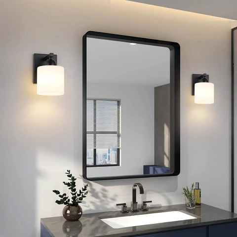 Chill Out Matte Black Milk Glass Wall Sconces Bringing Soft Warm Light To Your Space Premium Metal Build Rust Resistant Finish above a modern bathroom sink.