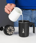 Person pouring milk into Tutto Crema Milk Frother Black Barista Grade, 1L Capacity, with double mesh insert on table