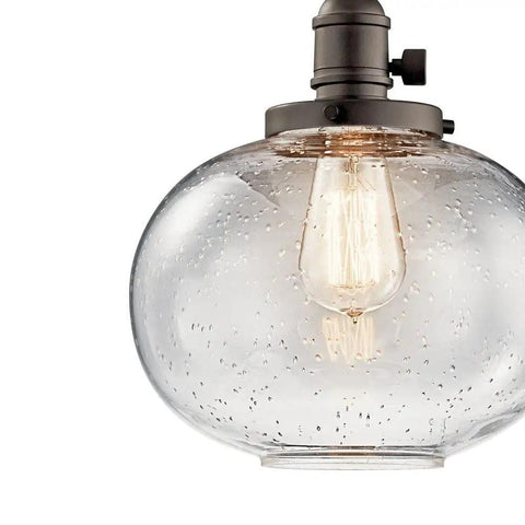 Avery 9.75 Inch One Light Mini Pendant With Clear Seeded Glass In Brushed Nickel Finish close-up of bulb and glass texture.