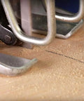 Jigsaw cutting wood; silver metal base plate and blade area visible with pencil line