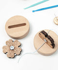 Wooden Thread Cutter Blade For Sewing With Daisy Flower Design on a wooden base, showcasing sharp precision blade and non slip silicone feet.