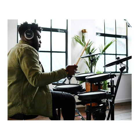 Musician playing Electronic V Drums Kit with Floating Hi Hat and Large Cymbal Pads for Realistic Drumming indoors.