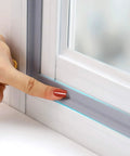 Person installing Door Draft Stopper Sweep Self Adhesive Weatherproof Seal Strip For Doors And Windows Cuttable 6.56 Ft Long Grey.